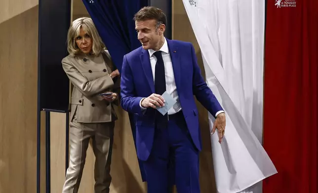 French President Emmanuel Macron and his wife Brigitte Macron leave the voting booth before voting in Le Touquet-Paris-Plage, northern France, Sunday, June 30, 2024. France is holding the first round of an early parliamentary election that could bring the country's first far-right government since Nazi occupation during World War II. The second round is on July 7, and the outcome of the vote remains highly uncertain (Yara Nardi, Pool via AP)