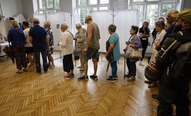 People queue to vote in Strasbourg, eastern France, Sunday, June 30, 2024. Voters across mainland France began casting ballots Sunday in the first round of exceptional parliamentary election that could put France's government in the hands of nationalist, far-right parties for the first time since the Nazi era. The outcome of the two-round election, which will wrap up July 7, could impact European financial markets, Western support for Ukraine and how France's nuclear arsenal and global military force are managed. (AP Photo/Jean-Francois Badias)