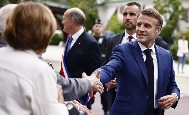French President Emmanuel Macron greets residents as he arrives at a polling station to to vote in the first round of the early French parliamentary elections, in Le Touquet-Paris-Plage, northern France, Sunday, June 30, 2024. France is holding the first round of an early parliamentary election that could bring the country's first far-right government since Nazi occupation during World War II. The second round is on July 7, and the outcome of the vote remains highly uncertain (Yara Nardi, Pool via AP)