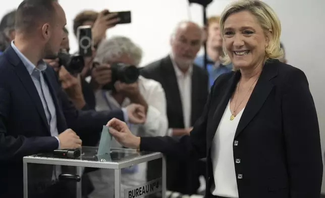 French far right leader Marine Le Pen casts her ballot for the first round of the parliamentary election, Sunday, June 30, 2024 in Henin-Beaumont, northern France. France is holding the first round of an early parliamentary election that could bring the country's first far-right government since Nazi occupation during World War II. The second round is on July 7, and the outcome of the vote remains highly uncertain. (AP Photo/Thibault Camus)