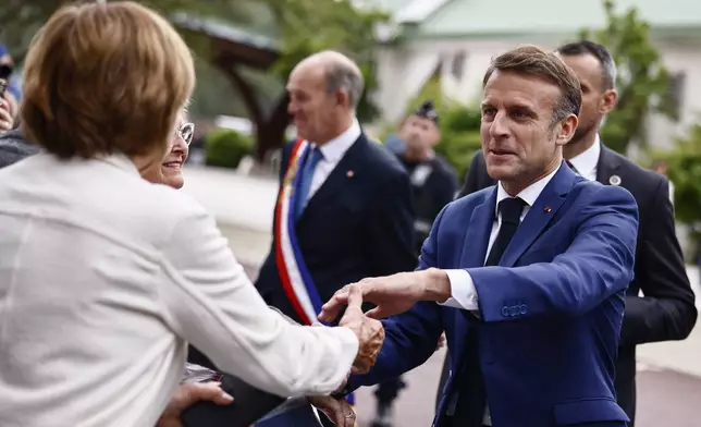 French President Emmanuel Macron greets residents as he arrives at a polling station to to vote in the first round of the early French parliamentary elections, in Le Touquet-Paris-Plage, northern France, Sunday, June 30, 2024. France is holding the first round of an early parliamentary election that could bring the country's first far-right government since Nazi occupation during World War II. The second round is on July 7, and the outcome of the vote remains highly uncertain (Yara Nardi, Pool via AP)