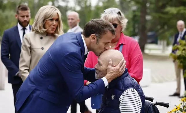 French President Emmanuel Macron kisses a man's head as he arrives at a polling station to to vote in the first round of the early French parliamentary elections, in Le Touquet-Paris-Plage, northern France, Sunday, June 30, 2024. France is holding the first round of an early parliamentary election that could bring the country's first far-right government since Nazi occupation during World War II. The second round is on July 7, and the outcome of the vote remains highly uncertain (Yara Nardi, Pool via AP)