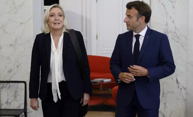 FILE - French President Emmanuel Macron, right, meets French far-right Rassemblement National (National Rally) leader Marine Le Pen at the Elysee Palace on June 21, 2022 in Paris. The perspective of a defeat in parliamentary elections mean he may have to share power with a prime minister from rival political party — that could possibly be far-right National Rally's president Jordan Bardella. Macron defeated twice the National Rally's leader Marine Le Pen in the presidential election, both in 2017 and 2022. (Ludovic Marin/Pool photo via AP, File)