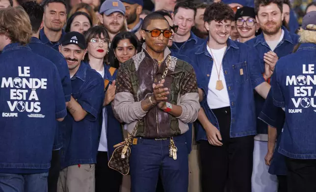 Creative director Pharrell Williams, center, accepts applause following the Louis Vuitton Spring Summer 2025 collection, that was presented in Paris, Tuesday, June 18, 2024. (Photo by Vianney Le Caer/Invision/AP)
