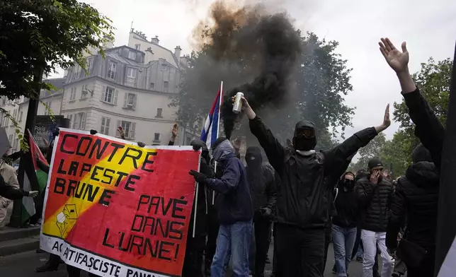 Protesters hold an anti-far right banner during a rally in Paris, Saturday, June 15, 2024. Anti-racism groups joined French unions and a brand-new left-wing coalition in protests in Paris and across France on Saturday against the surging nationalist far right as frenzied campaigning is underway ahead of snap parliamentary elections. (AP Photo/Michel Euler)