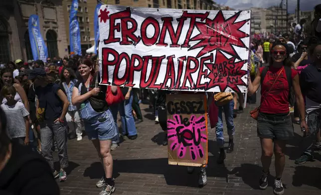 Protesters march with a banner that reads "Popular Front", during a demonstration in Marseille, southern France, Saturday, June 15, 2024. Anti-racism groups joined French unions and a brand-new left-wing coalition in protests in Paris and across France on Saturday against the surging nationalist far right as frenzied campaigning is underway ahead of snap parliamentary elections. (AP Photo/Daniel Cole)