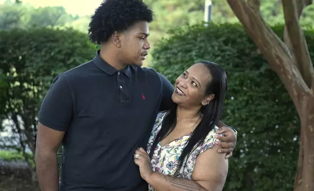 Robin Alderman, right, looks up to her son, Camden Alderman, 21, who has a rare disease called Wiskott-Aldrich syndrome, as they pose for a portrait near their home in Greensboro, N.C., Wednesday, June 12, 2024. (AP Photo/Chuck Burton)