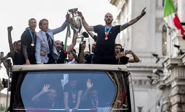 FILE - Italy's coach Roberto Mancini, front second left, celebrates with players in Rome, Monday, July 12, 2021, their victory at the Euro 2020 soccer championships in a final played at Wembley stadium in London on Sunday. The Euros kick off in Munich, Friday June 14, when host country Germany plays Scotland at Bayern Munich's Allianz Arena. The tournament begins with six groups of four teams. (Roberto Monaldo/ Lapresse via AP, File)