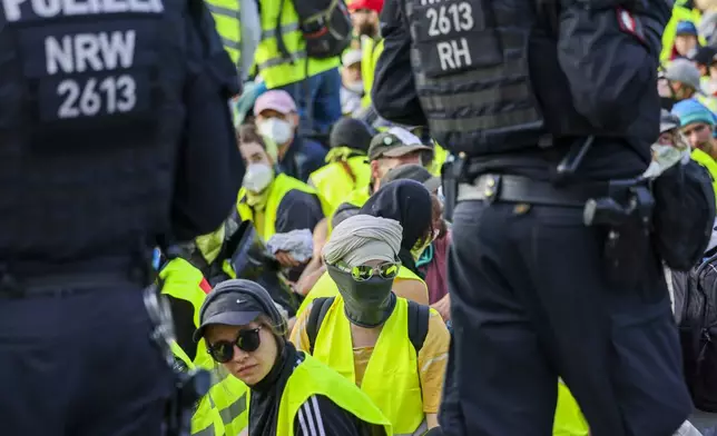 Demonstrators sit on a street surrounded by police officers in Essen, Germany Saturday, June 29, 2024. A few hours before the start of the AfD national party conference, demonstrators had their first clash with the police on Saturday morning.(dpa via AP)
