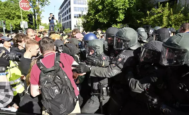 Demonstrators and police confront each other in Essen, Germany, Saturday, June 29, 2024. A few hours before the start of the far right AfD national party conference, demonstrators clashed with the police for the first time on Saturday morning. (Henning Kaiser/dpa via AP)