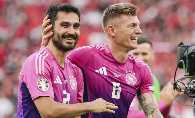 Germany's Ilkay Gundogan, left, and Toni Kroos, right, smile after a Group A match at the Euro 2024 soccer tournament in Stuttgart, Germany, Wednesday, June 19, 2024. (Christian Charisius/dpa via AP)