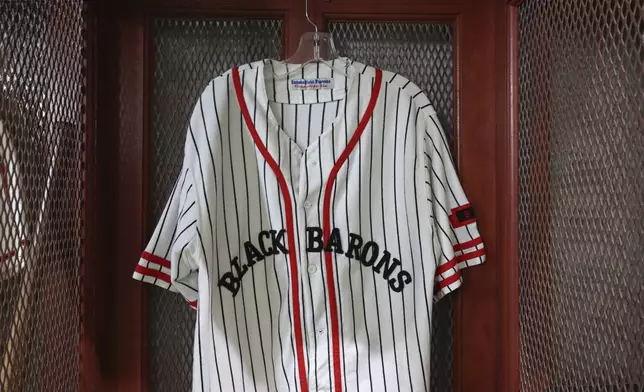 A replica Birmingham Black Barons jersey hangs in a locker inside Rickwood Field before the start of a baseball game between the St. Louis Cardinals and the San Francisco Giants, Thursday, June 20, 2024, in Birmingham, Ala. Rickwood Field was home to the Black Barons of the Negro Leagues and is where legend Willie Mays got his start in professional baseball. (AP Photo/Vasha Hunt)