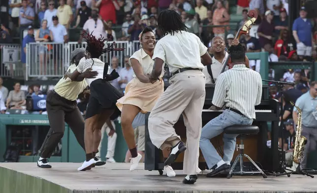 Performers dance before the start of a baseball game between the St. Louis Cardinals and the San Francisco Giants at Rickwood Field, Thursday, June 20, 2024, in Birmingham, Ala. (AP Photo/Vasha Hunt)