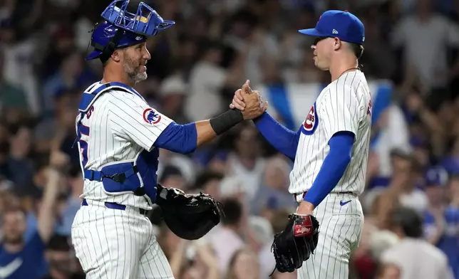 Chicago Cubs catcher Yan Gomes, left, celebrates with relief pitcher Keegan Thompson after the Cubs defeated the San Francisco Giants in a baseball game in Chicago, Tuesday, June 18, 2024. (AP Photo/Nam Y. Huh)