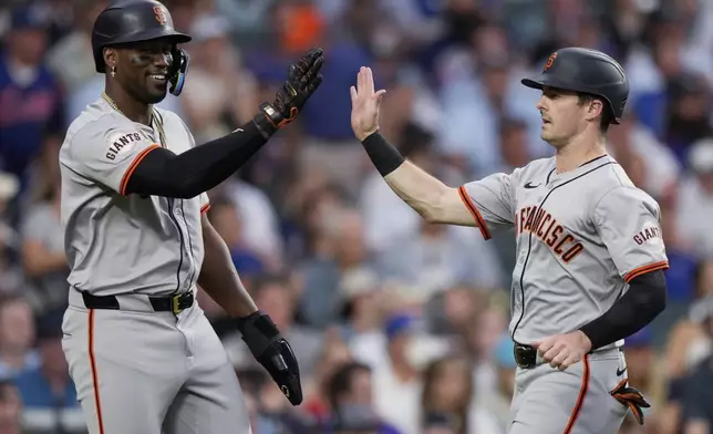 San Francisco Giants' Jorge Soler, left, celebrates with Mike Yastrzemski after scoring on a two-run double by Curt Casali during the fifth inning of the team's baseball game against the Chicago Cubs in Chicago, Tuesday, June 18, 2024. (AP Photo/Nam Y. Huh)