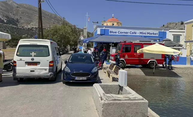 A view of an ambulance and a fire brigade van are on a beachfront of Symi island, Greece, Sunday, June 9, 2024. Police said that a body believed to be that of missing British TV presenter Michael Mosley was found on a Greek island Sunday morning. (AP Photo/Antonis Mystiloglou)