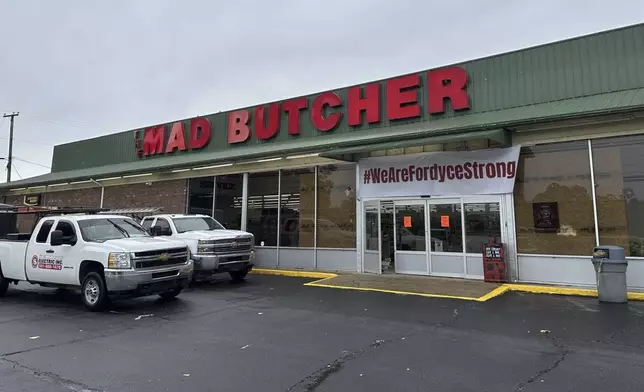 Trucks sit parked in front of the Mad Butcher grocery store in Fordyce, Ark., Wednesday, June 26, 2024. The store has remained closed in the days following a mass shooting that killed four people, prompting volunteers to scramble to set up food distribution sites for residents. (AP Photo/Andrew DeMillo)