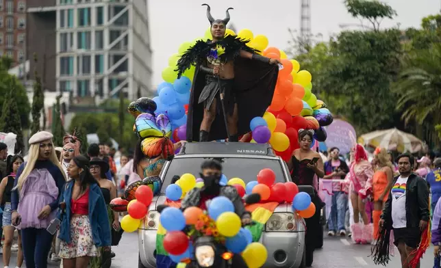 A reveler, wearing a Maleficent headband, rides atop a float during a Gay Pride parade marking the culmination of LGBTQ+ Pride month, in Guatemala City, Saturday, June 29, 2024. (AP Photo/Moises Castillo)
