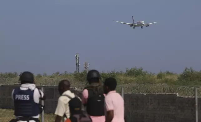 Journalists cover the arrival of a plane carrying police from Kenya at the Toussaint Louverture International Airport in Port-au-Prince, Haiti, Tuesday, June 25, 2024. The first U.N.-backed contingent of foreign police arrived nearly two years after the Caribbean country requested help to quell a surge in gang violence. (AP Photo/Odelyn Joseph)