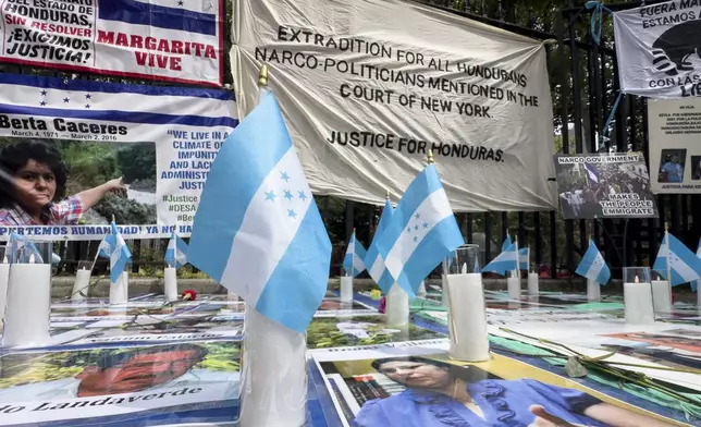 Protestors signs and images victims of Honduran drug traffickers outside Federal court, Wednesday, June 26, 2024, in New York. Former Honduran President Juan Orlando Hernandez is scheduled for sentencing after being convicted in New York of conspiring with drug traffickers, his military and police to enable tons of cocaine to reach the United States. (AP Photo/John Minchillo)