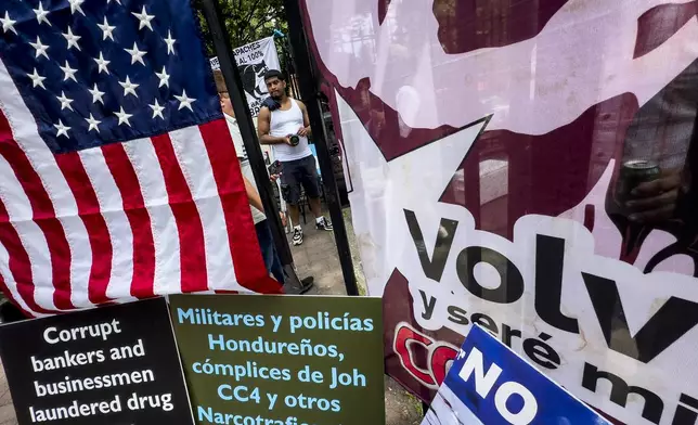 Protestors signs and images victims of Honduran drug traffickers outside Federal court, Wednesday, June 26, 2024, in New York. Former Honduran President Juan Orlando Hernandez is scheduled for sentencing after being convicted in New York of conspiring with drug traffickers, his military and police to enable tons of cocaine to reach the United States. (AP Photo/John Minchillo)