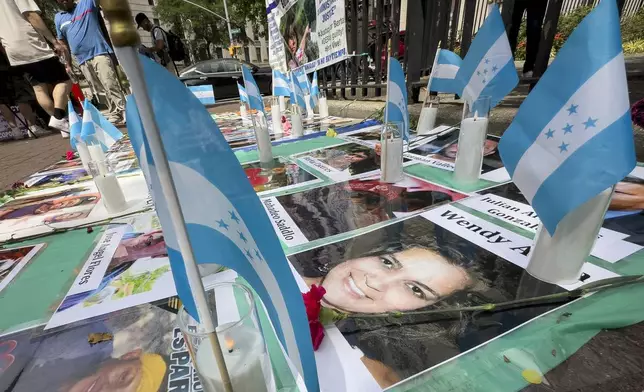 Protestors signs and images victims of Honduran drug traffickers outside Federal court, Wednesday, June 26, 2024, in New York. Former Honduran President Juan Orlando Hernandez is scheduled for sentencing after being convicted in New York of conspiring with drug traffickers, his military and police to enable tons of cocaine to reach the United States. (AP Photo/John Minchillo)