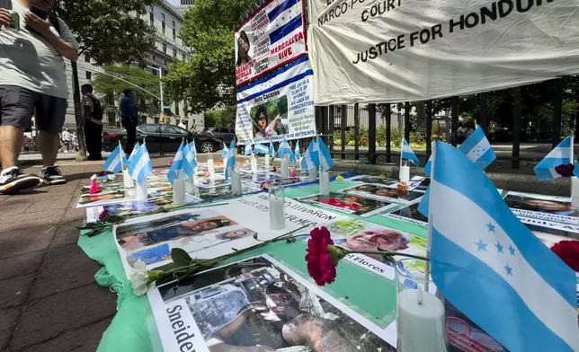 Protestors signs and images victims of Honduran drug traffickers outside Federal court, Wednesday, June 26, 2024, in New York. Former Honduran President Juan Orlando Hernandez is scheduled for sentencing after being convicted in New York of conspiring with drug traffickers, his military and police to enable tons of cocaine to reach the United States. (AP Photo/John Minchillo)