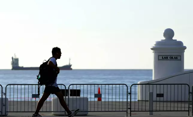 A man walks on the inside of barricades set up along the Florida Panthers Stanley Cup Celebration parade route on Fort Lauderdale Beach on Friday, June 28, 2024. (Amy Beth Bennett /South Florida Sun-Sentinel via AP)