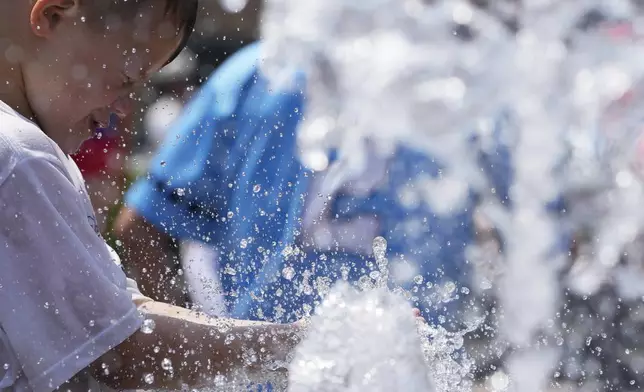 A boy cools off at a fountain during hot weather in Chicago, Sunday, June 16, 2024. (AP Photo/Nam Y. Huh)
