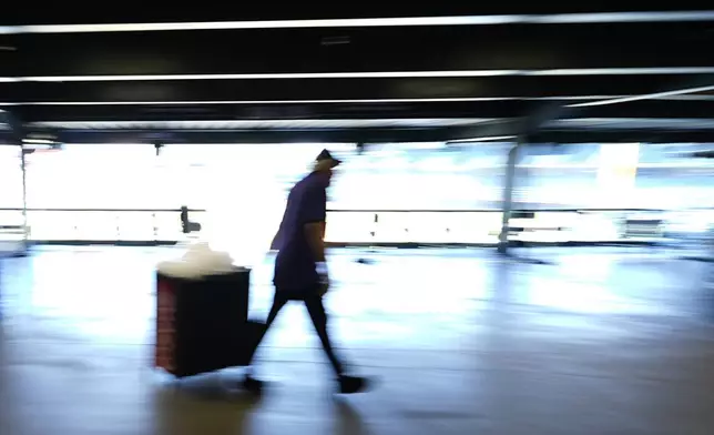 A concession worker pulls a tub of ice to a stand on the main concourse of Coors Field before the Colorado Rockies host the Pittsburgh Pirates in a baseball game Sunday, June 16, 2024, in Denver. (AP Photo/David Zalubowski)
