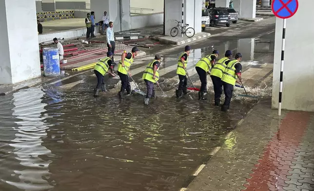 A crew removes water outside the Indira Gandhi International Airport after a heavy downpour in New Delhi, India, Friday, June 28, 2024. A portion of the canopy at a departure terminal of the airport collapsed early Friday as heavy pre-monsoon rains lashed the Indian capital. (AP Photo/Shonal Ganguly)