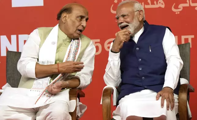 Prime Minister Narendra Modi, right, chats with Defense Minister Rajnath Singh before addressing supporters at the Bharatiya Janata Party (BJP) headquarters, in New Delhi, India, Tuesday, June 4, 2024. (AP Photo/Manish Swarup)