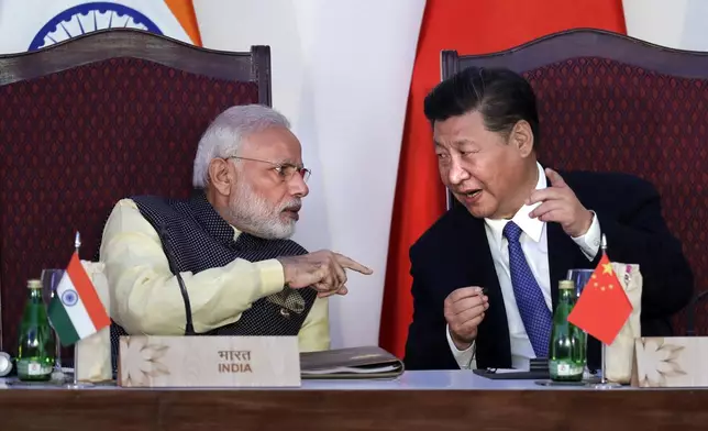 FILE- Indian Prime Minister Narendra Modi, left, talks with Chinese President Xi Jinping at a signing ceremony by foreign ministers during the BRICS summit in Goa, India, Oct. 16, 2016. (AP Photo/Manish Swarup, File)