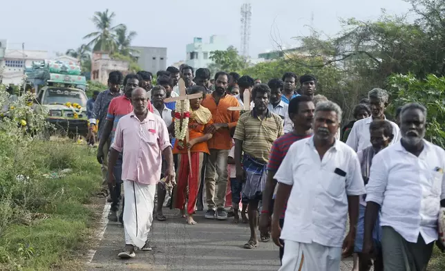 Relatives of a man, who died after drinking illegally brewed liquor, walk in a funeral procession for his burial in Kallakurichi district of the southern Indian state of Tamil Nadu, India, Thursday, June 20, 2024. The state's chief minister M K Stalin said the 34 died after consuming liquor that was tainted with methanol, according to the Press Trust of India news agency. (AP Photo/R. Parthibhan)