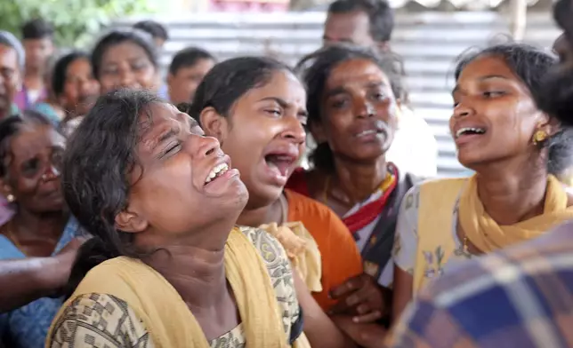 Relatives of a person, who died after drinking illegally brewed liquor, cry, in Kallakurichi district of the southern Indian state of Tamil Nadu, India, Thursday, June 20, 2024. The state's chief minister M K Stalin said the 34 died after consuming liquor that was tainted with methanol, according to the Press Trust of India news agency. (AP Photo/R. Parthibhan)