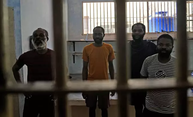 Detainees from Nigeria stand inside their cell at Tanjungpinang Central Immigration Detention Center on Bintan Island, Indonesia, Wednesday, May 15, 2024. This three-story detention facility, with its barred windows and fading paint, is home to dozens of detainees facing uncertain futures, including whether they will ever return to their homelands, in conditions that closely resemble a prison. (AP Photo/Dita Alangkara)