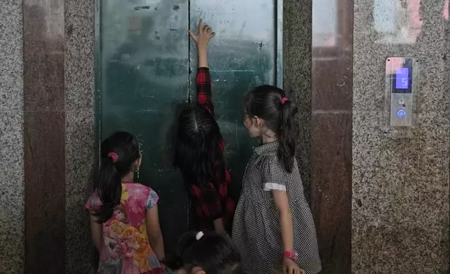 Children play near an elevator at a hotel turned into a shelter for refugees in Batam, an island in northwestern Indonesia, Thursday, May 16, 2024. The former tourist hotel was converted in 2015 into a temporary shelter that today houses 228 refugees from conflict-torn nations including Afghanistan, Somalia, Sudan and elsewhere. (AP Photo/Dita Alangkara)
