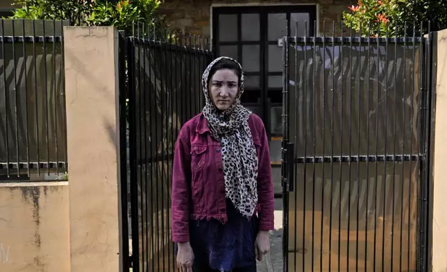 Rahima Farhangdost, an Afghan refugee who has been living in Indonesia since August 2014 after the Taliban banned her from working as a nurse and teacher, stands outside her boarding house in Bogor, Indonesia, Thursday, May 30, 2024. "I heard the process is faster and that after two or three years, we could get resettlement. So that's why I came to Indonesia. But it's been a very, very long time — 10 years now. I really regret it. I would prefer to die in Afghanistan, and not have come to Indonesia," she said. (AP Photo/Dita Alangkara)