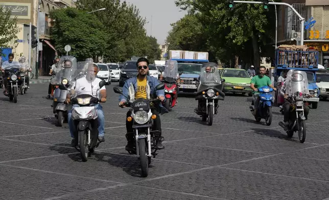 Motorbikes cross an intersection in downtown in Tehran, Iran, Saturday, June 29, 2024. Iran will hold a runoff presidential election to replace the late hard-line President Ebrahim Raisi after an initial vote saw the top candidates not secure an outright win in the lowest turnout poll ever held in the Islamic Republic by percentage. (AP Photo/Vahid Salemi)