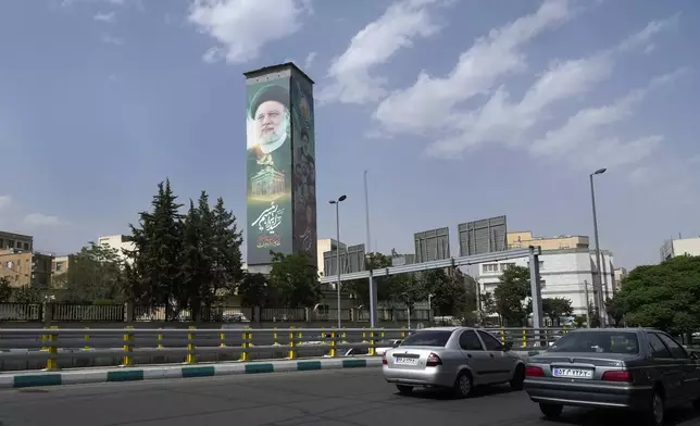 Cars drive past a huge billboard showing the late Iranian President Ebrahim Raisi on a highway in Tehran, Iran, Saturday, June 29, 2024. Iran will hold a runoff presidential election on July 5 to replace the late hard-line President Ebrahim Raisi after an initial vote saw the top candidates not secure an outright win in the lowest turnout poll ever held in the Islamic Republic by percentage. (AP Photo/Vahid Salemi)