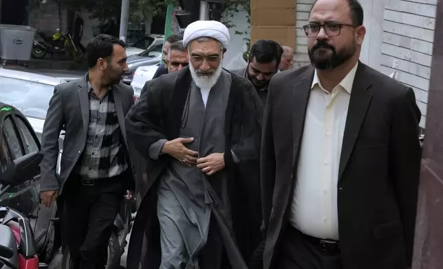 Candidate for June 28, Iran's presidential election Mostafa Pourmohammadi, center, a former Minister of Justice, arrives for his press conference in Tehran, Iran, Sunday, June 23, 2024. (AP Photo/Vahid Salemi)