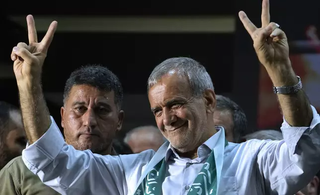 Reformist candidate for Iran's June 28, presidential election Masoud Pezeshkian flashes the victory sign in his campaign rally in Tehran, Iran, Sunday, June 23, 2024. (AP Photo/Vahid Salemi)