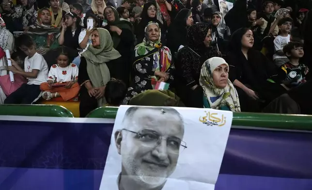 Supporters of Tehran Mayor Alireza Zakani, shown in the poster, a candidate for the June 28 presidential election, attend his campaign rally in Tehran, Iran, Sunday, June 23, 2024. (AP Photo/Vahid Salemi)