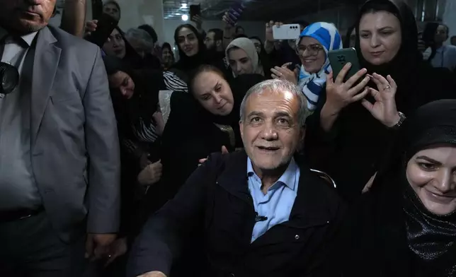 Reformist candidate for Iran's June 28, presidential election Masoud Pezeshkian is surrounded by his supporters, during a campaign rally in Tehran, Iran, Friday, June 14, 2024. (AP Photo/Vahid Salemi)