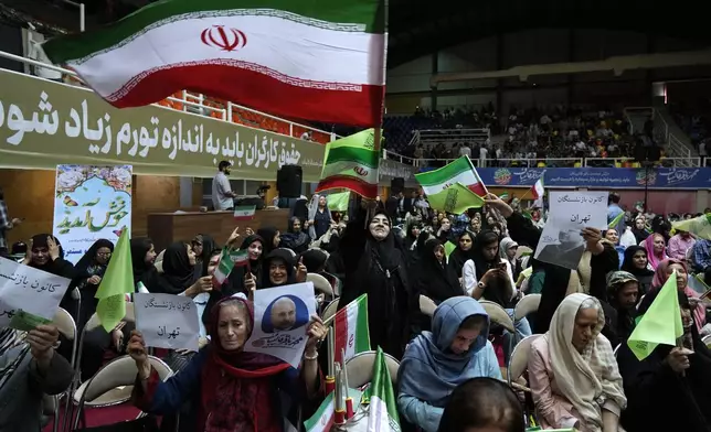 Supporters of Mohammad Bagher Qalibaf, the most prominent candidate for the June 28, presidential election, who is Iran's parliament speaker, wave the country's flags during his campaign rally in Tehran, Iran, Tuesday, June 18, 2024. (AP Photo/Vahid Salemi)