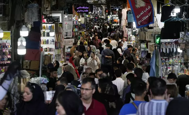 People walk through the old main bazaar of Tehran, Iran, Thursday, June 13, 2024. The rise of the “Hamster Kombat” app in Iran highlights a harsher truth facing the Islamic Republic's economy ahead of its presidential election this week to replace the late President Ebrahim Raisi, who died in a helicopter crash in May. (AP Photo/Vahid Salemi)