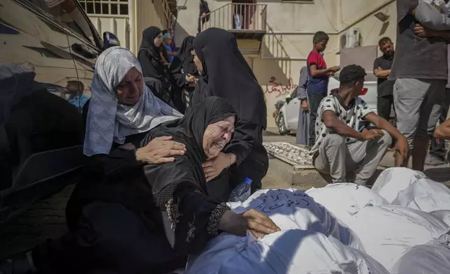 Palestinians mourn their relatives killed in the Israeli bombardment of the Gaza Strip in a hospital in Deir al Balah on Tuesday, June 18, 2024. (AP Photo/Abdel Kareem Hana)