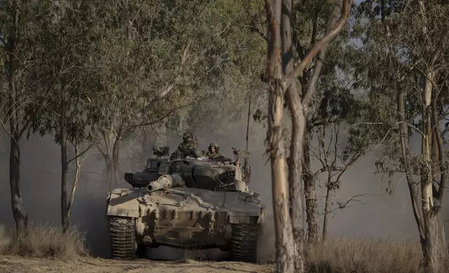 Israeli soldiers move on the top of a tank near the Israeli-Gaza border, as seen from southern Israel, Saturday, June 29, 2024. (AP Photo/Leo Correa)