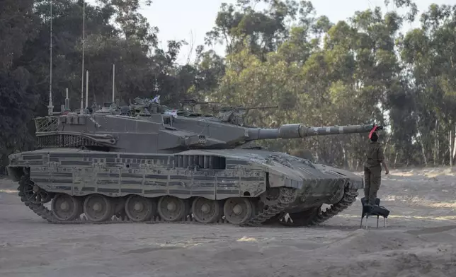 Israeli soldier check a tank near the Gaza Strip border in southern Israel, Thursday, June 13, 2024. The army is battling Palestinian militants across Gaza in the war ignited by Hamas' Oct. 7 attack into Israel. (AP Photo/Ohad Zwigenberg)