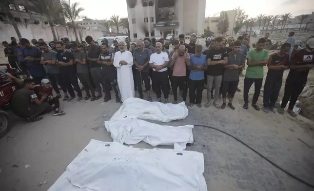 Palestinians pray for victims of Israeli bombardment before their burial in Khan Younis, southern Gaza Strip, Friday, June 21, 2024. (AP Photo /Jehad Alshrafi)